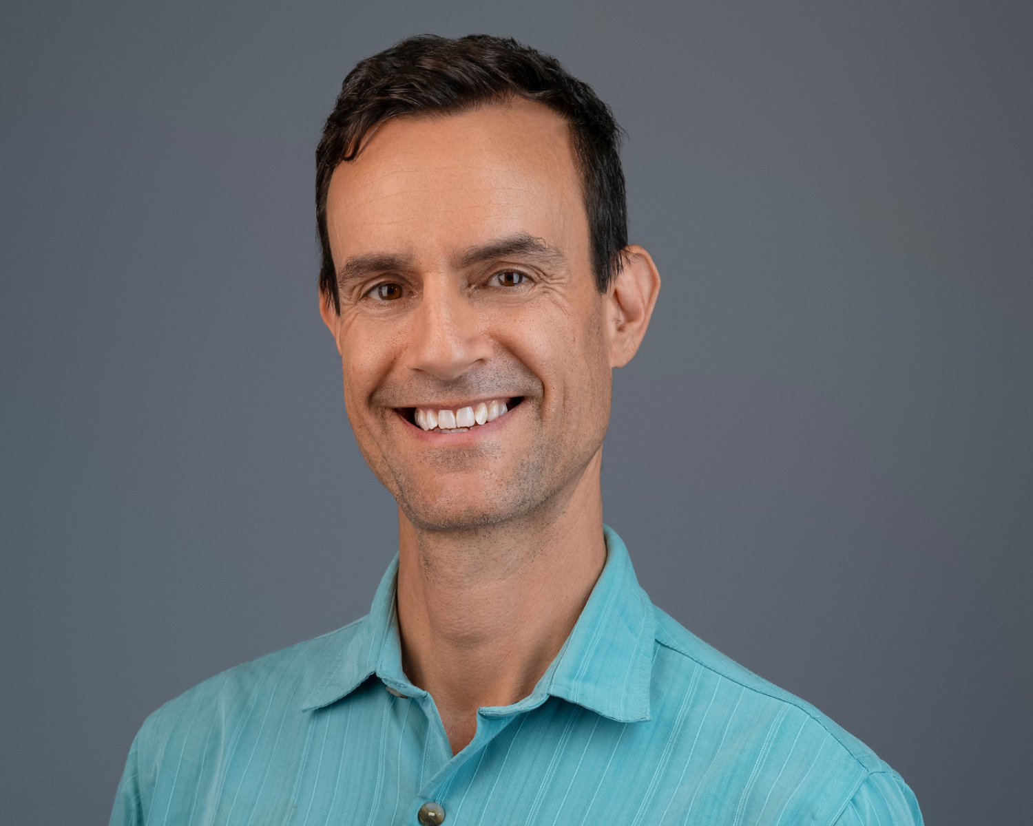 Travis Richardson headshot portrait in a teal shirt