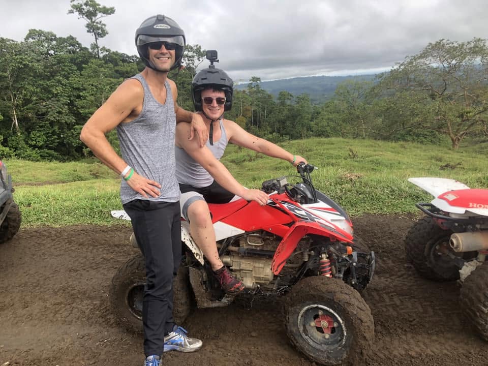 Two retreat leaders on ATVs during a muddy adventure excursion in Costa Rica