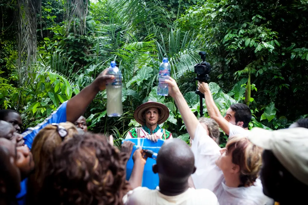Retreat participants contributing clean water to a local community in a lush jungle setting